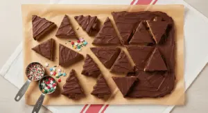 Peanut Butter No Bake bars cut into triangular pieces and tree shapes