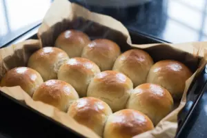 Honey Wheat Sourdough Dinner Rolls 12 Freshly baked sourdough dinner rolls in buttered pan