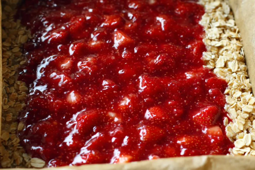 Strawberry Oatmeal Crumble Bars 6 Adding strawberry filling to oatmeal crumble bars