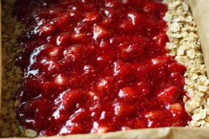 Strawberry Oatmeal Crumble Bars 9 Adding strawberry filling to oatmeal crumble bars