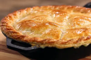 sourdough chicken pot pie with golden flaky crust in cast iron skillet