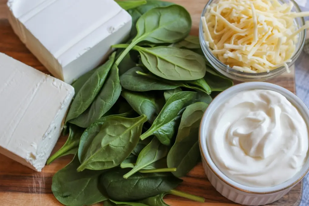 Ingredients for homemade spinach dip recipe on wooden cutting board