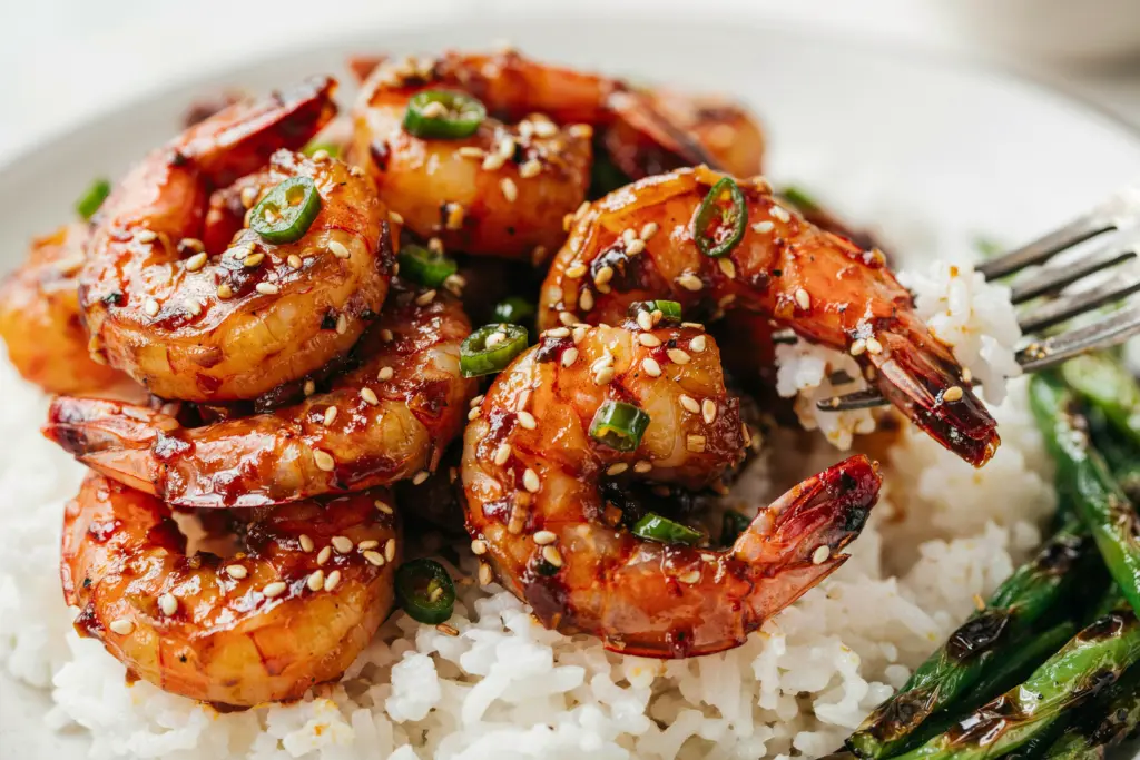Asian Chilli Garlic Prawns Recipe 7 Asian Chilli Garlic Prawns served over a bed of white rice next to blistered green beans