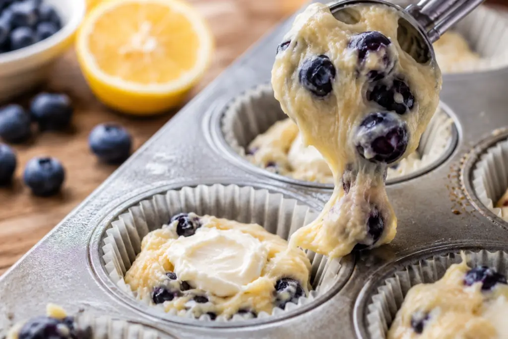 Blueberry Lemon Cream Cheese Muffins Recipe 3 blueberry lemon cream cheese muffins batter being scooped